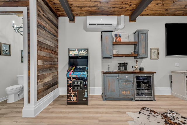 bar with wine cooler, gray cabinetry, beam ceiling, and an AC wall unit