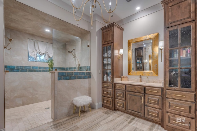 bathroom with hardwood / wood-style flooring, tiled shower, and vanity