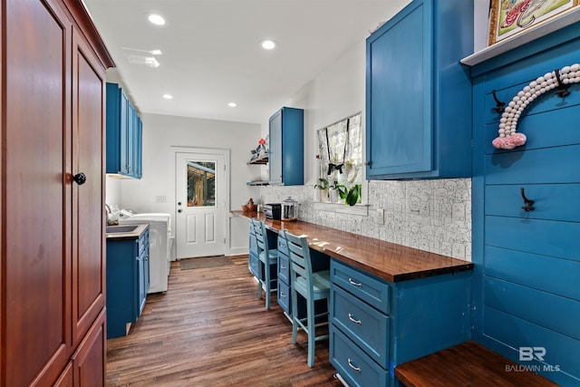 kitchen with blue cabinetry, dark hardwood / wood-style floors, and wood counters