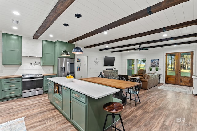 kitchen featuring decorative light fixtures, ceiling fan, appliances with stainless steel finishes, and green cabinetry