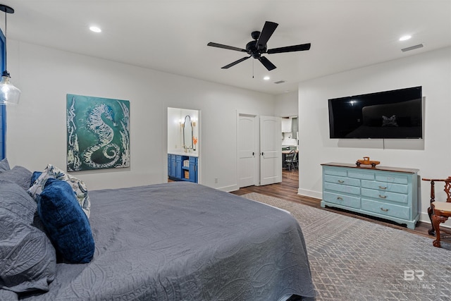 bedroom with ceiling fan, dark wood-type flooring, and connected bathroom