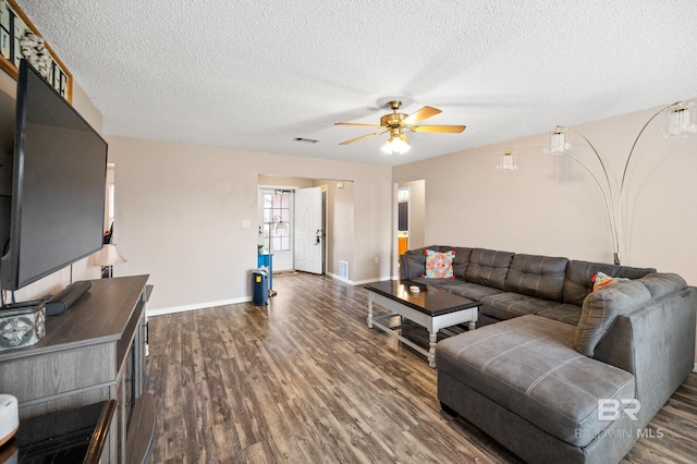 living room with ceiling fan, dark hardwood / wood-style flooring, and a textured ceiling