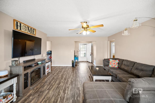 living room with ceiling fan, dark hardwood / wood-style flooring, and a textured ceiling