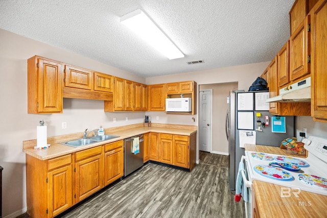 kitchen featuring dishwasher, stove, sink, dark hardwood / wood-style floors, and a textured ceiling