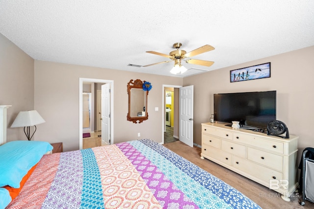 bedroom with ceiling fan, ensuite bathroom, a textured ceiling, and light hardwood / wood-style flooring