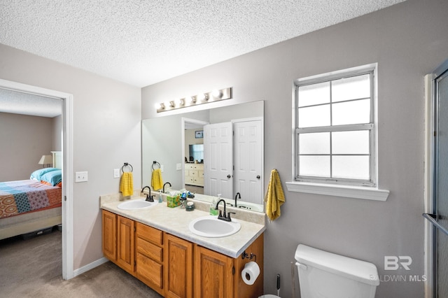 bathroom with vanity, a textured ceiling, and toilet