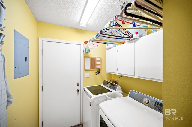 laundry area with a textured ceiling, electric panel, cabinets, and washing machine and dryer