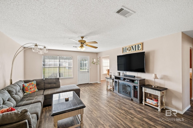 living room with a textured ceiling, dark hardwood / wood-style flooring, and ceiling fan