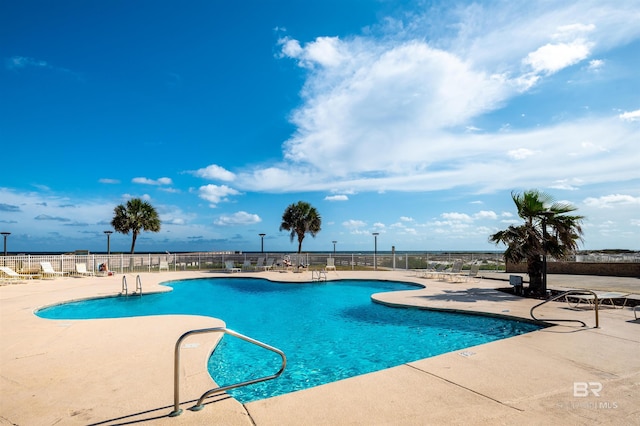 community pool featuring fence and a patio