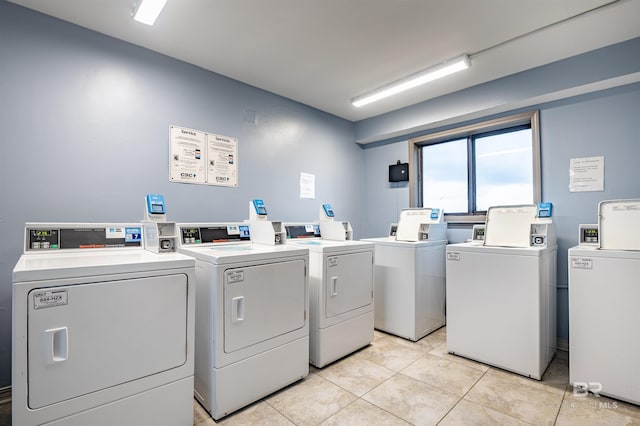 common laundry area with independent washer and dryer and light tile patterned floors
