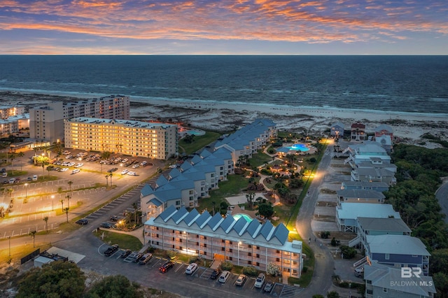 aerial view at dusk featuring a water view
