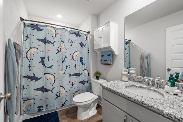 bathroom with toilet, wood finished floors, vanity, and a shower with curtain