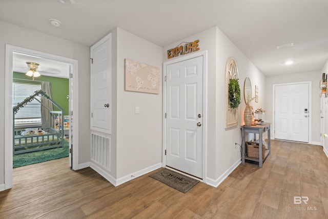 entryway featuring visible vents, light wood-type flooring, baseboards, and a ceiling fan