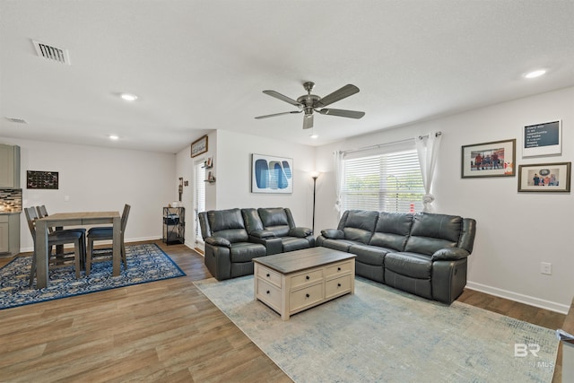 living area with visible vents, light wood-style flooring, a ceiling fan, and recessed lighting