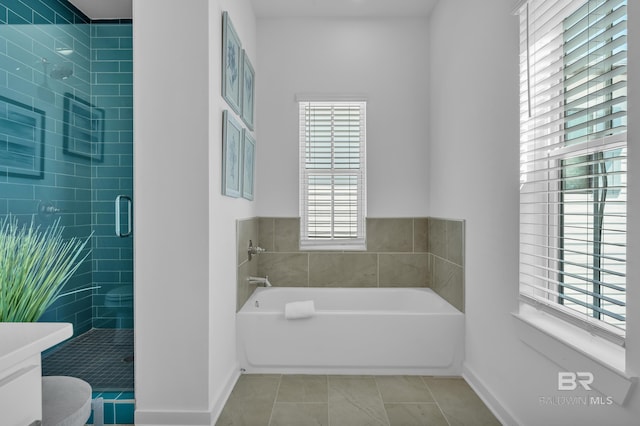 bathroom featuring tile patterned flooring, baseboards, a bath, and a shower stall