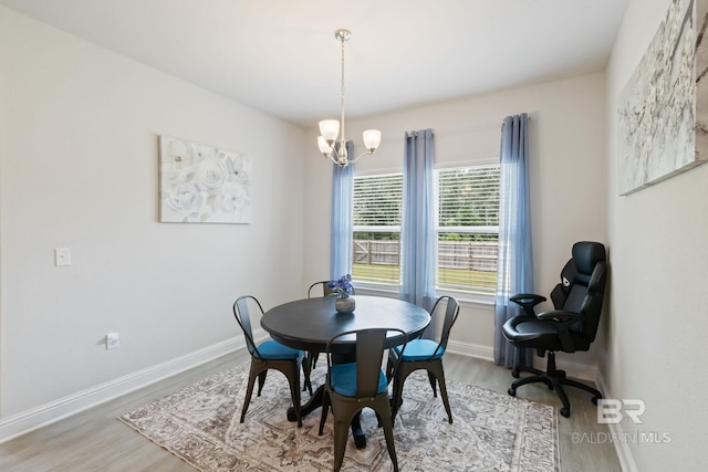 dining area with an inviting chandelier and light hardwood / wood-style floors