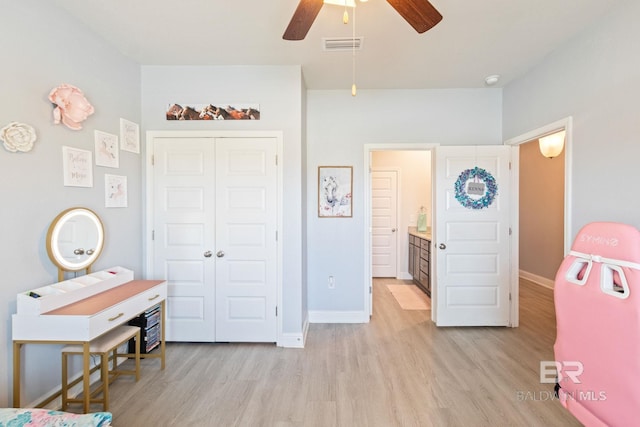 bedroom featuring ceiling fan, light hardwood / wood-style flooring, and a closet