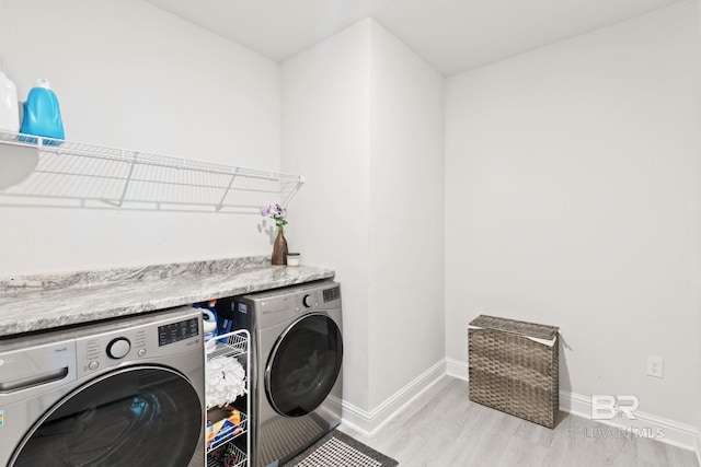 clothes washing area featuring light hardwood / wood-style floors and independent washer and dryer