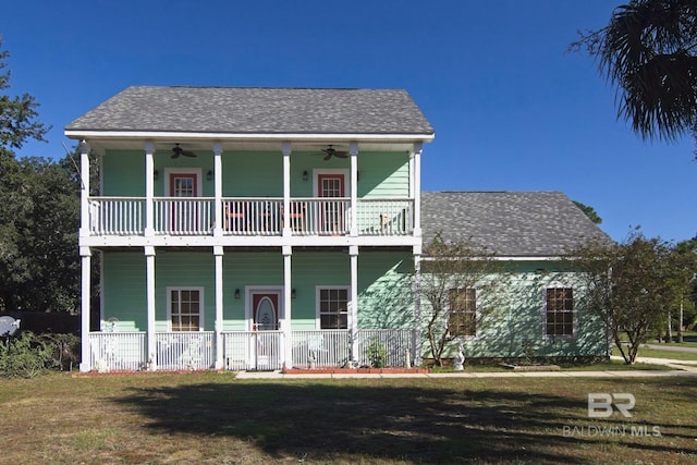 1912 Brigadoon Trl, Gulf Shores, AL 36542 - view of front of house featuring a balcony, covered porch, a ceiling fan, and a front lawn