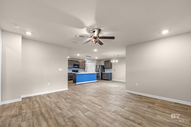 unfurnished living room featuring visible vents, light wood-style floors, baseboards, and ceiling fan