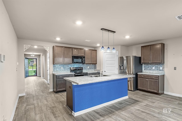 kitchen featuring a sink, light countertops, light wood-style flooring, and stainless steel appliances