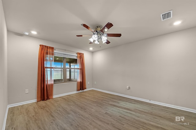 empty room featuring a ceiling fan, wood finished floors, visible vents, baseboards, and recessed lighting