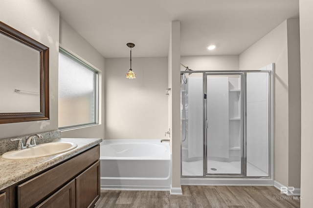 bathroom with a garden tub, vanity, wood finished floors, and a shower stall