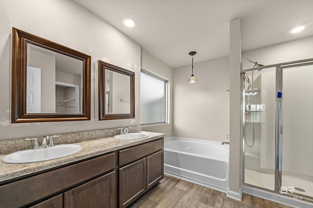 bathroom with a sink, a stall shower, double vanity, and a bath