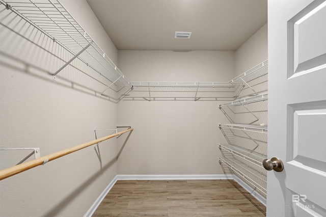 spacious closet featuring wood finished floors and visible vents