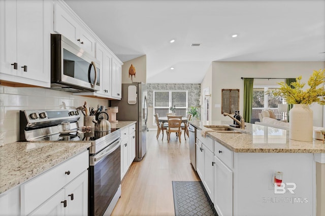 1203 Hayward Loop, Foley, AL 36535 - kitchen featuring a sink, white cabinets, appliances with stainless steel finishes, decorative backsplash, and a center island with sink