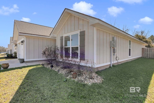 1203 Hayward Loop, Foley, AL 36535 - view of property exterior featuring a shingled roof, fence, a lawn, and board and batten siding