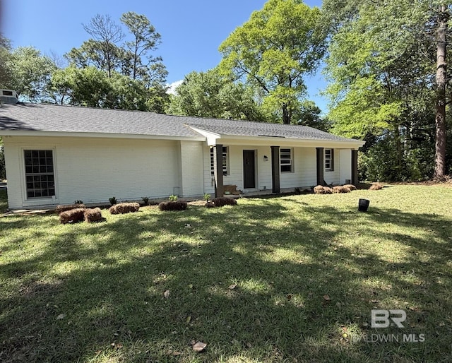view of front of property with brick siding, a shingled roof, a front lawn, and covered porch