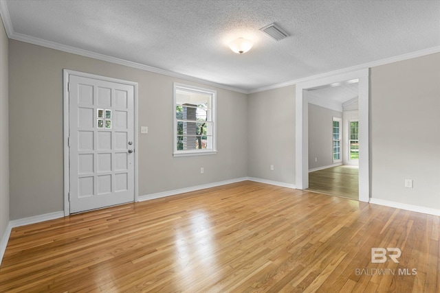 entryway featuring ornamental molding, a healthy amount of sunlight, light wood-style floors, and visible vents