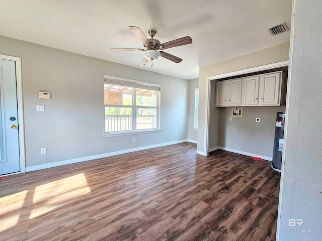 interior space with dark hardwood / wood-style flooring, water heater, and ceiling fan