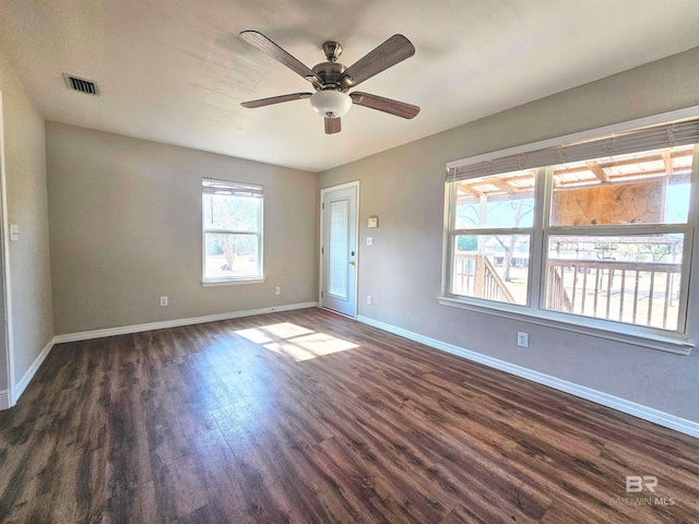 empty room featuring dark wood-type flooring and ceiling fan