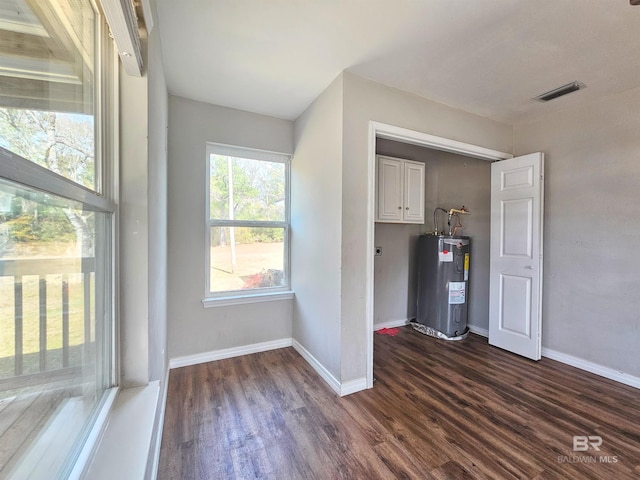 interior space with dark wood-type flooring and water heater