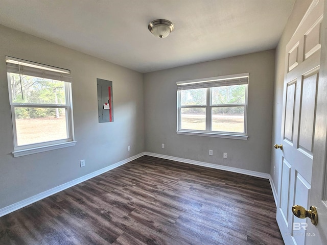 unfurnished bedroom with multiple windows, dark wood-type flooring, and electric panel