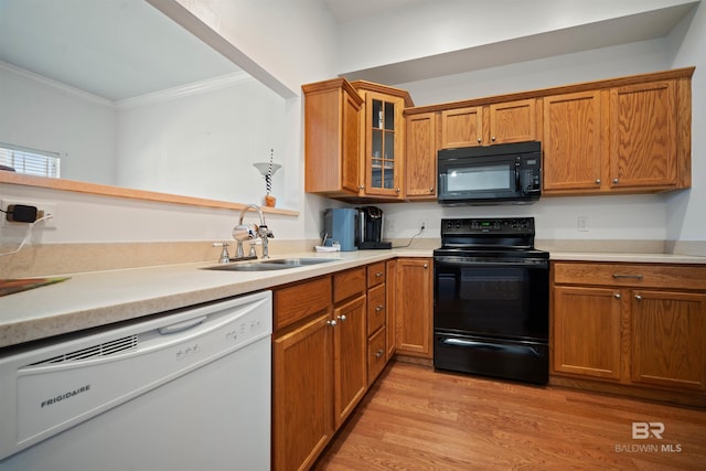 4 Yacht Club Dr Unit 174, Daphne, AL 36526 - kitchen featuring black appliances, a sink, crown molding, light wood finished floors, and brown cabinets