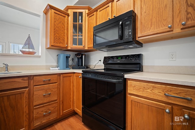 4 Yacht Club Dr Unit 174, Daphne, AL 36526 - kitchen with black appliances, brown cabinetry, light countertops, glass insert cabinets, and a sink