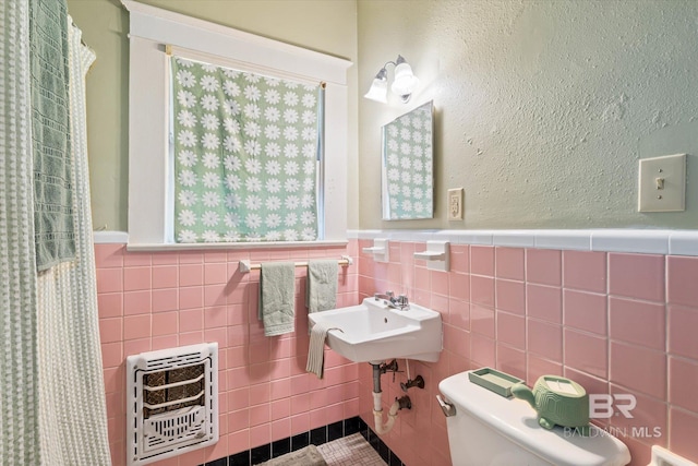 121 Westwood St, Mobile, AL 36606 - full bath with a wainscoted wall, a sink, toilet, tile walls, and heating unit