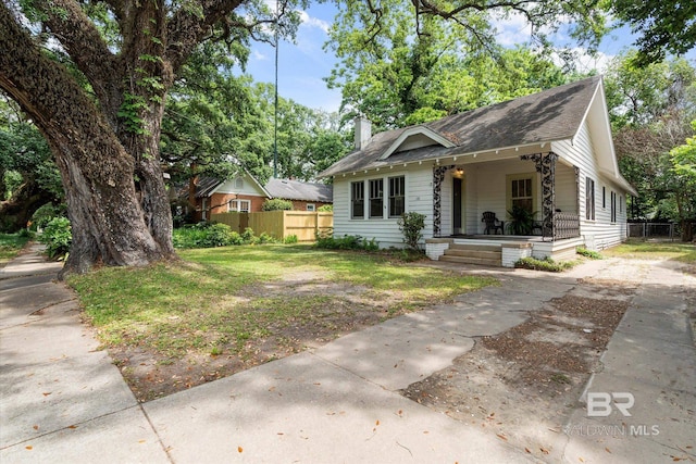121 Westwood St, Mobile, AL 36606 - bungalow-style home with a chimney, fence, driveway, covered porch, and roof with shingles