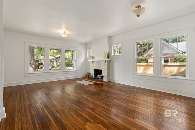 121 Westwood St, Mobile, AL 36606 - unfurnished living room with hardwood / wood-style flooring, a fireplace, and a healthy amount of sunlight