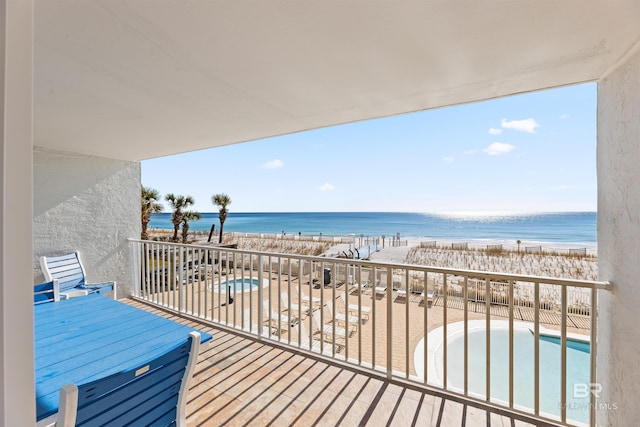 balcony featuring a beach view and a water view