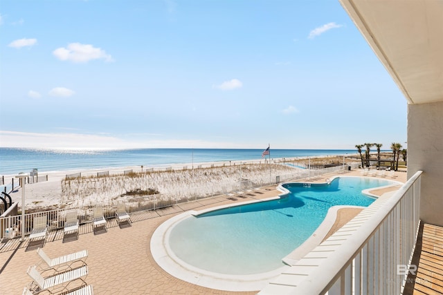 view of pool featuring a view of the beach and a water view