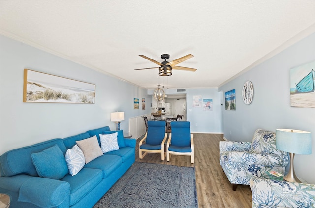 living room featuring ceiling fan, crown molding, and hardwood / wood-style floors