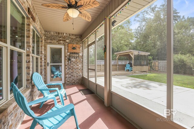 unfurnished sunroom featuring ceiling fan