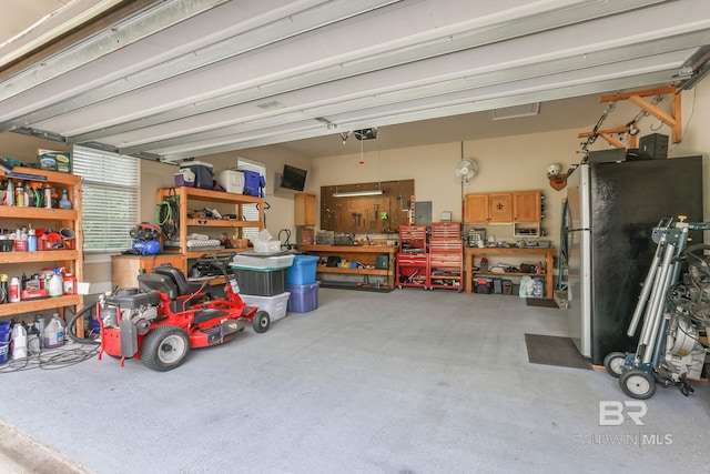 garage with a garage door opener, stainless steel fridge, and a workshop area