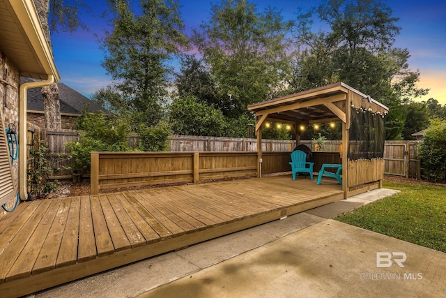 deck at dusk with a gazebo and a patio area