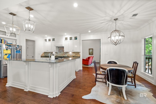 kitchen with a chandelier, tasteful backsplash, ornamental molding, and freestanding refrigerator