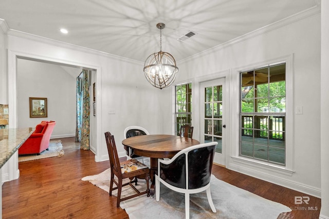 dining space with crown molding, visible vents, dark wood-style flooring, and a chandelier